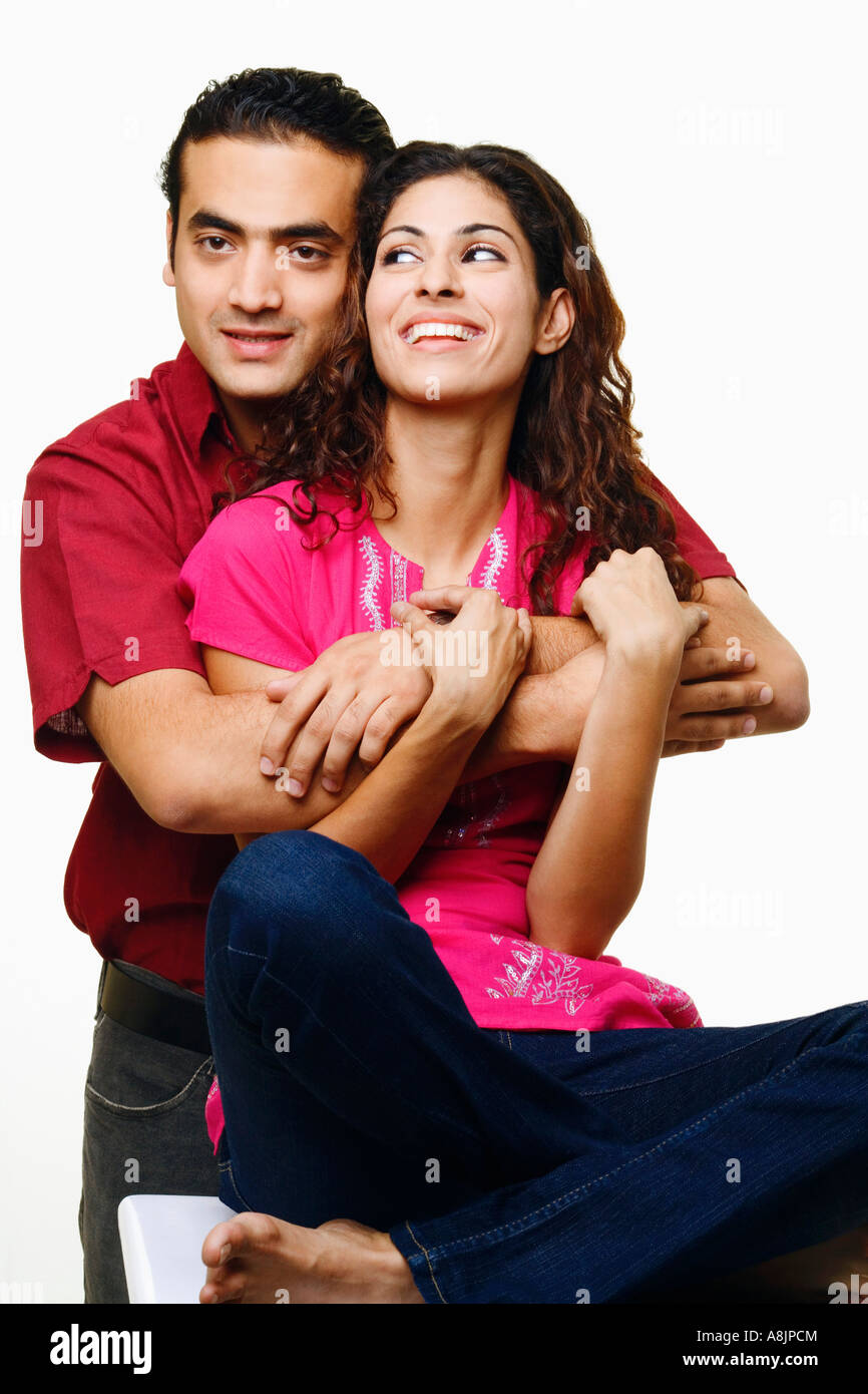 Young man embracing a young woman from behind and smiling Stock Photo ...