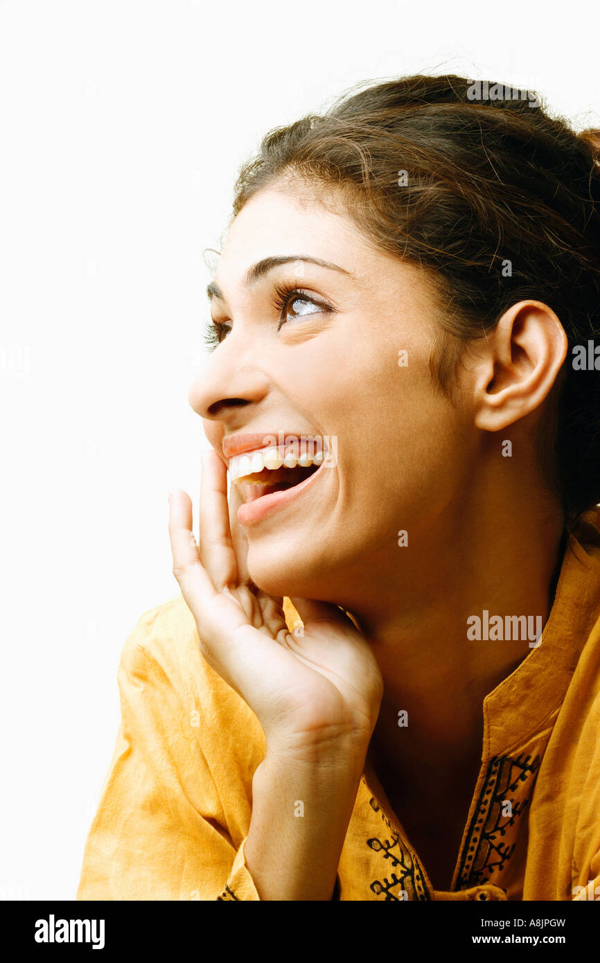 Close-up of a young woman smiling with her hand on her chin Stock Photo ...