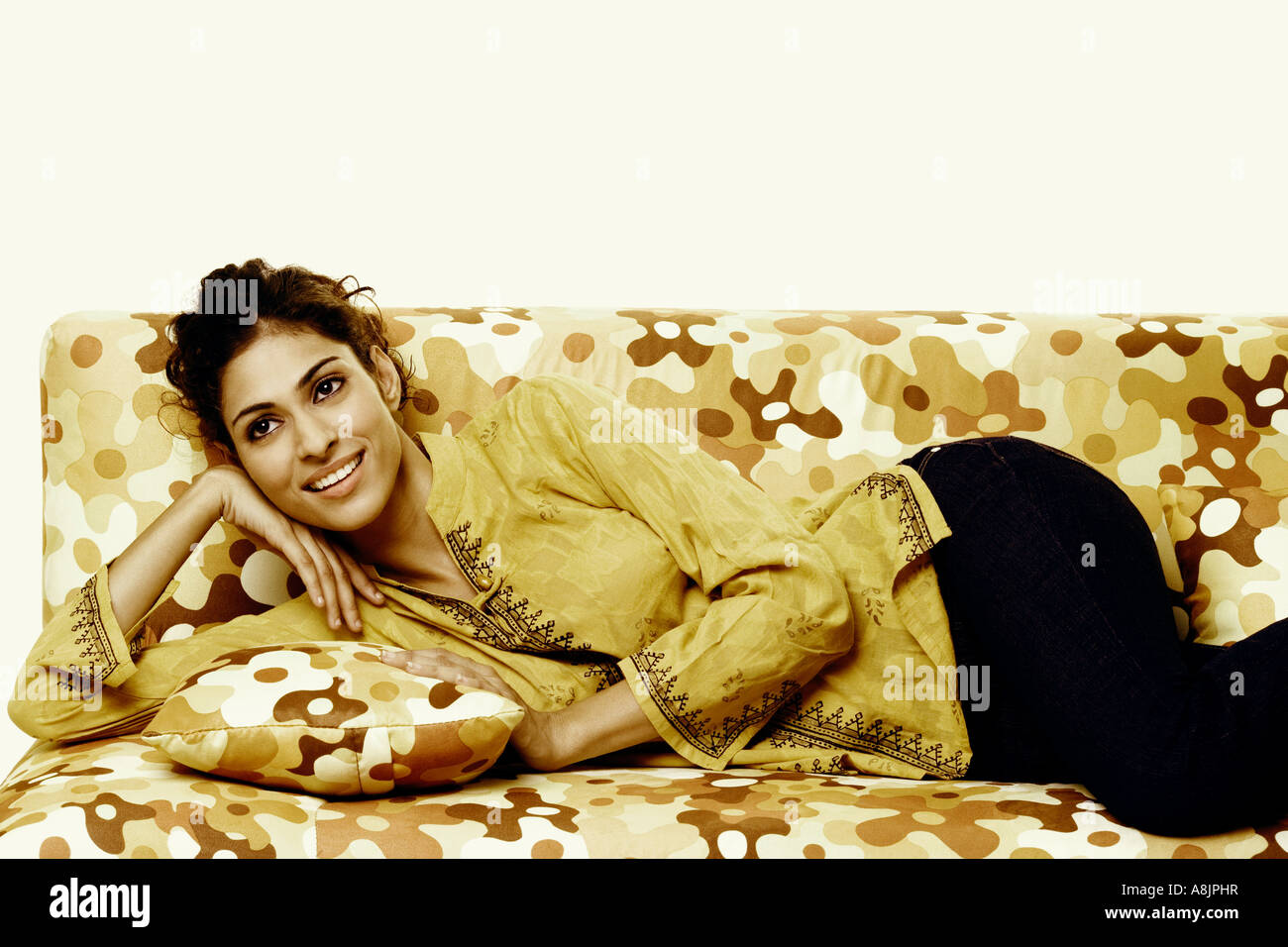 Close-up of a young woman lying on a couch and smiling Stock Photo - Alamy