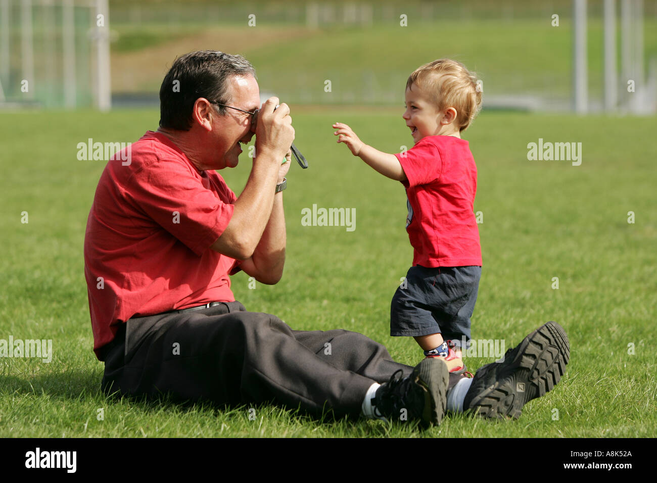 GRANDAD TAKES A PICTURE OF HIS GRANDSON Stock Photo