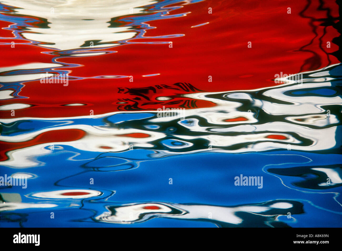 Abstract background image of harbour sea with red and blue swirling reflection Stock Photo