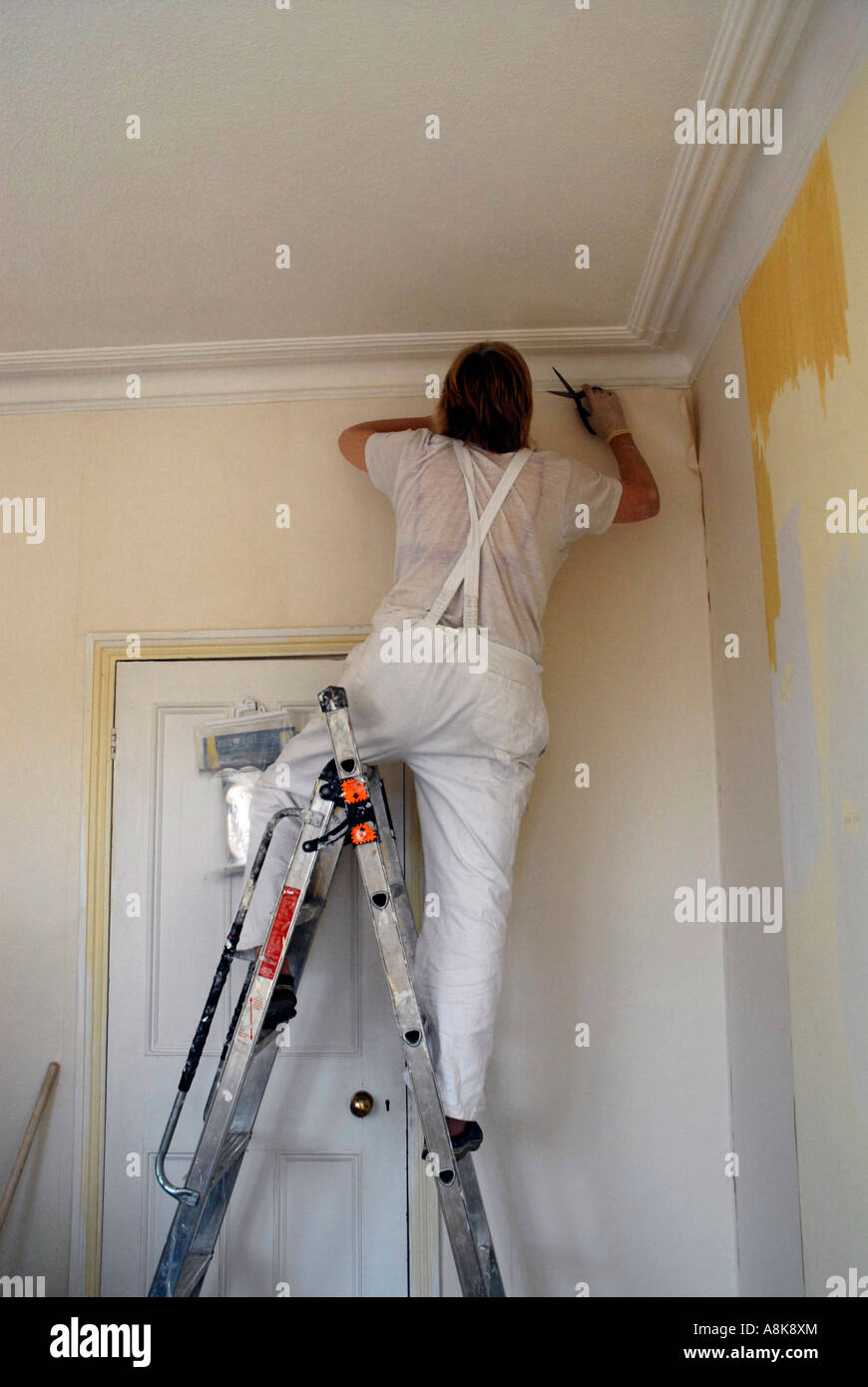 Woman Diy Papering Her Room Walls With Lining Paper Stock