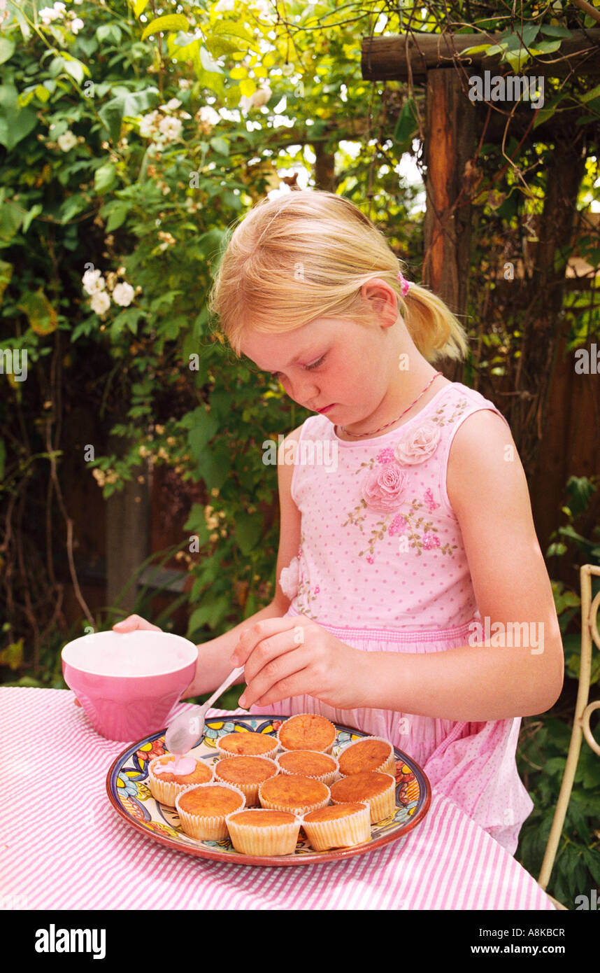A young girl decorating cakes Stock Photo