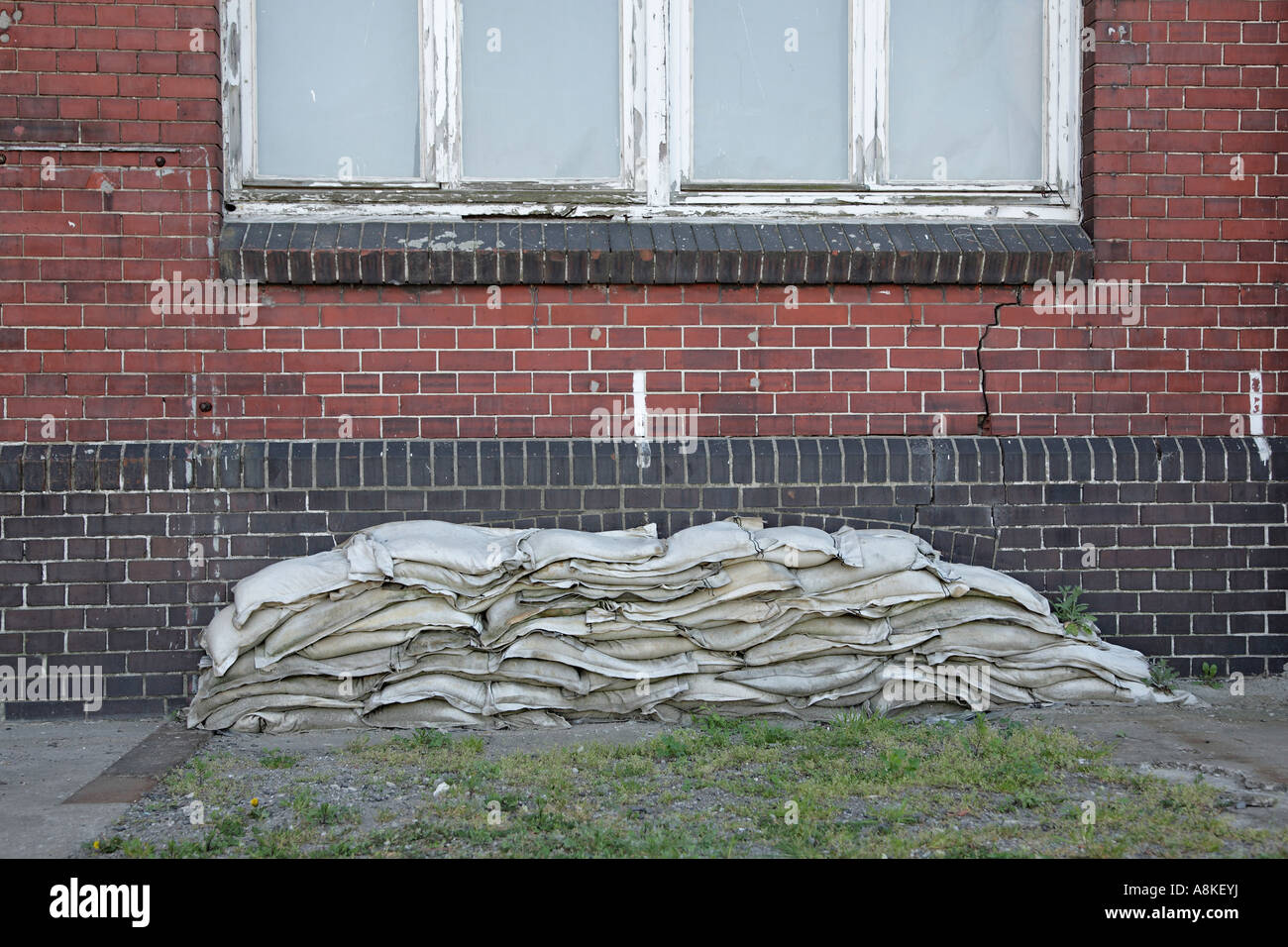 Sand bags in front of basement window, flood, inundation Stock Photo