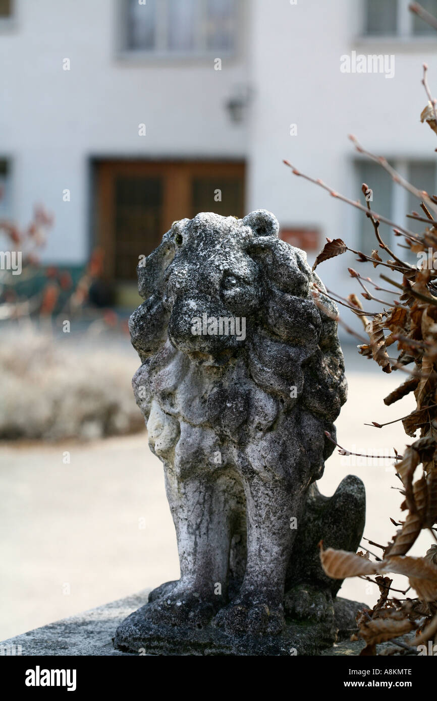 Small decorative stone figure (sculpture) of lion at the entrance (in front) of a residential house in Switzerland during early spring sunny day Stock Photo