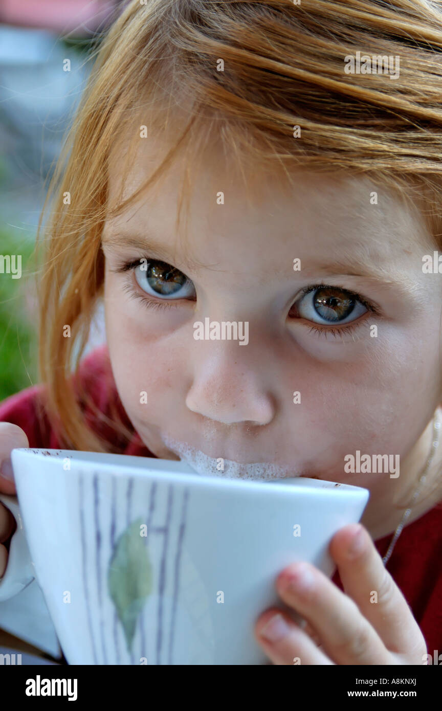 Child drinks milk from a cup Stock Photo
