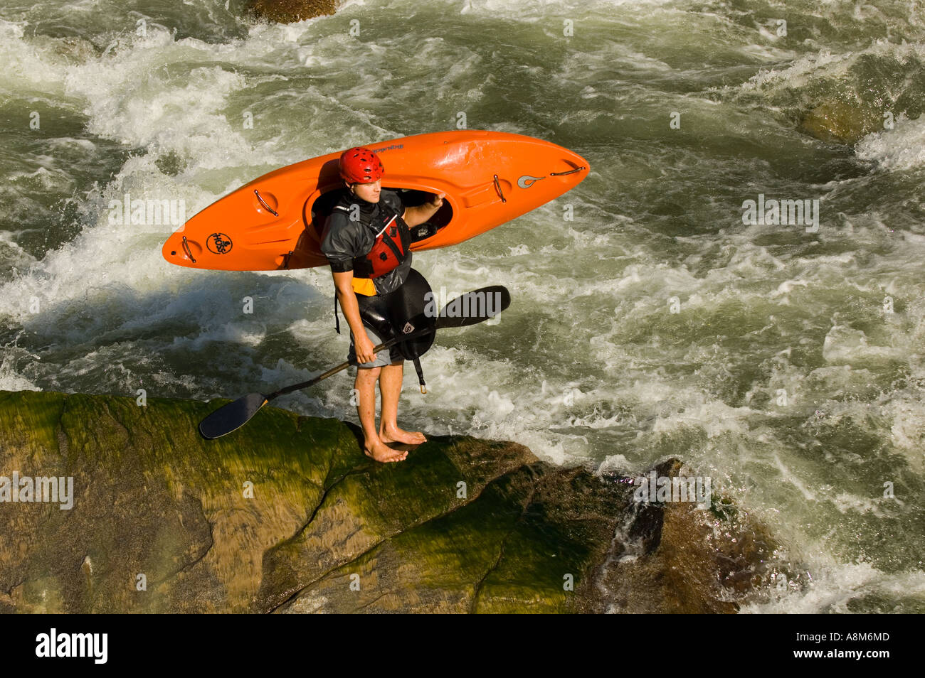 IDAHO Kayaker with kayak on shoulder surveying whitewater rapid South Fork of the Payette River near Boise MR Stock Photo