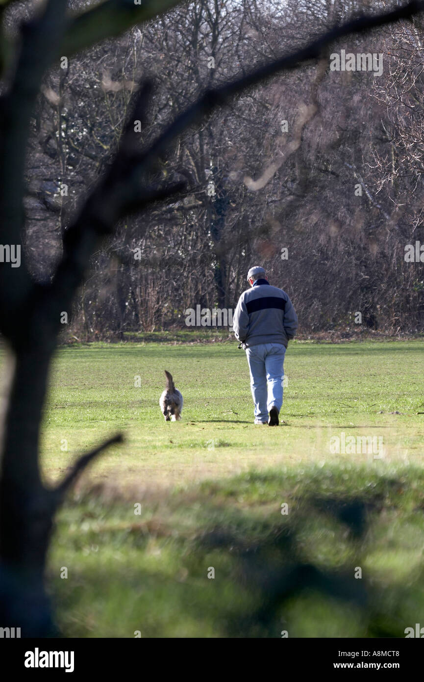 Man walking dog on Barnes Common Richmond Greater London Surrey England