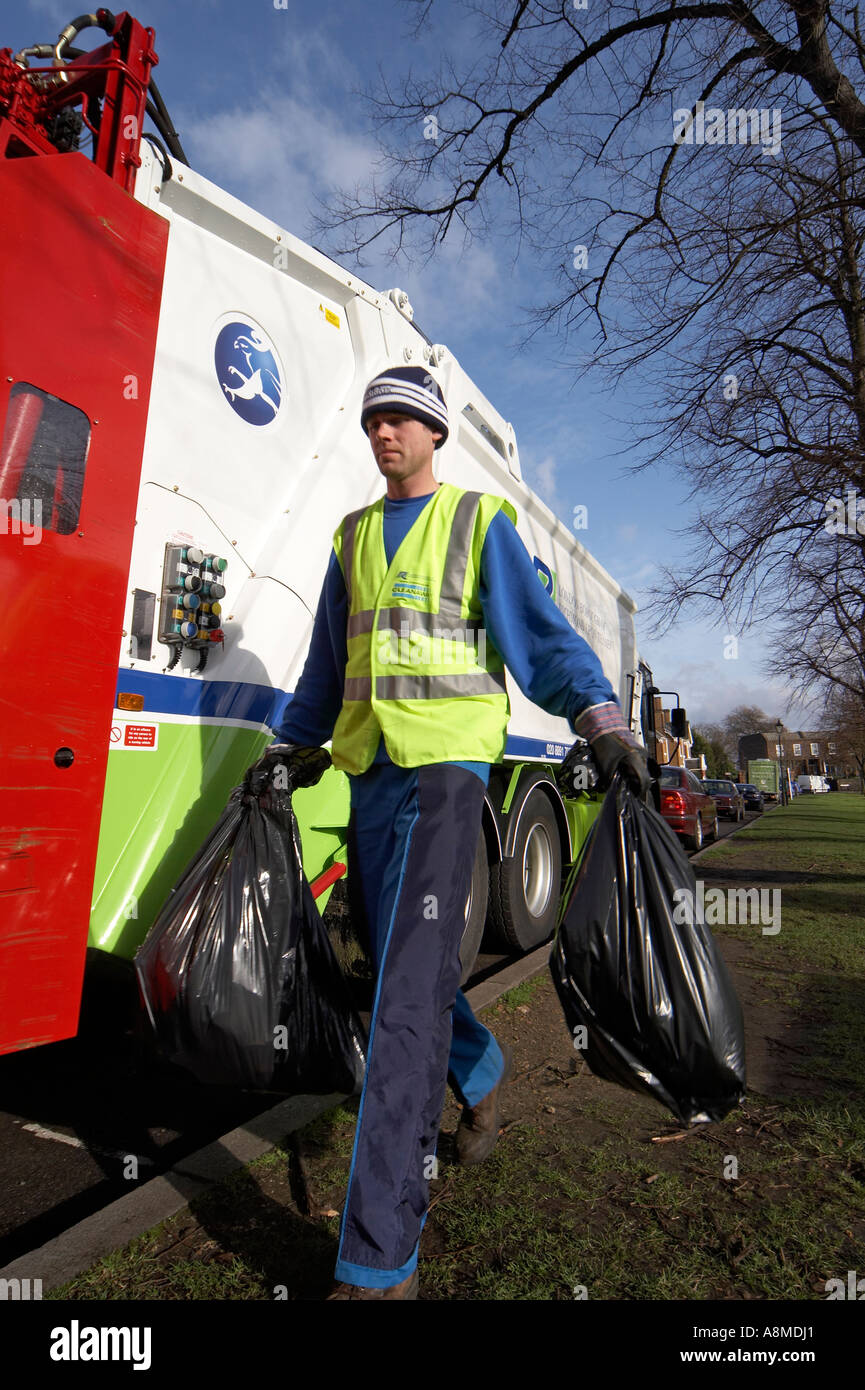 Waste rubbish or trash lorry or truck with man carrying black bin bags
