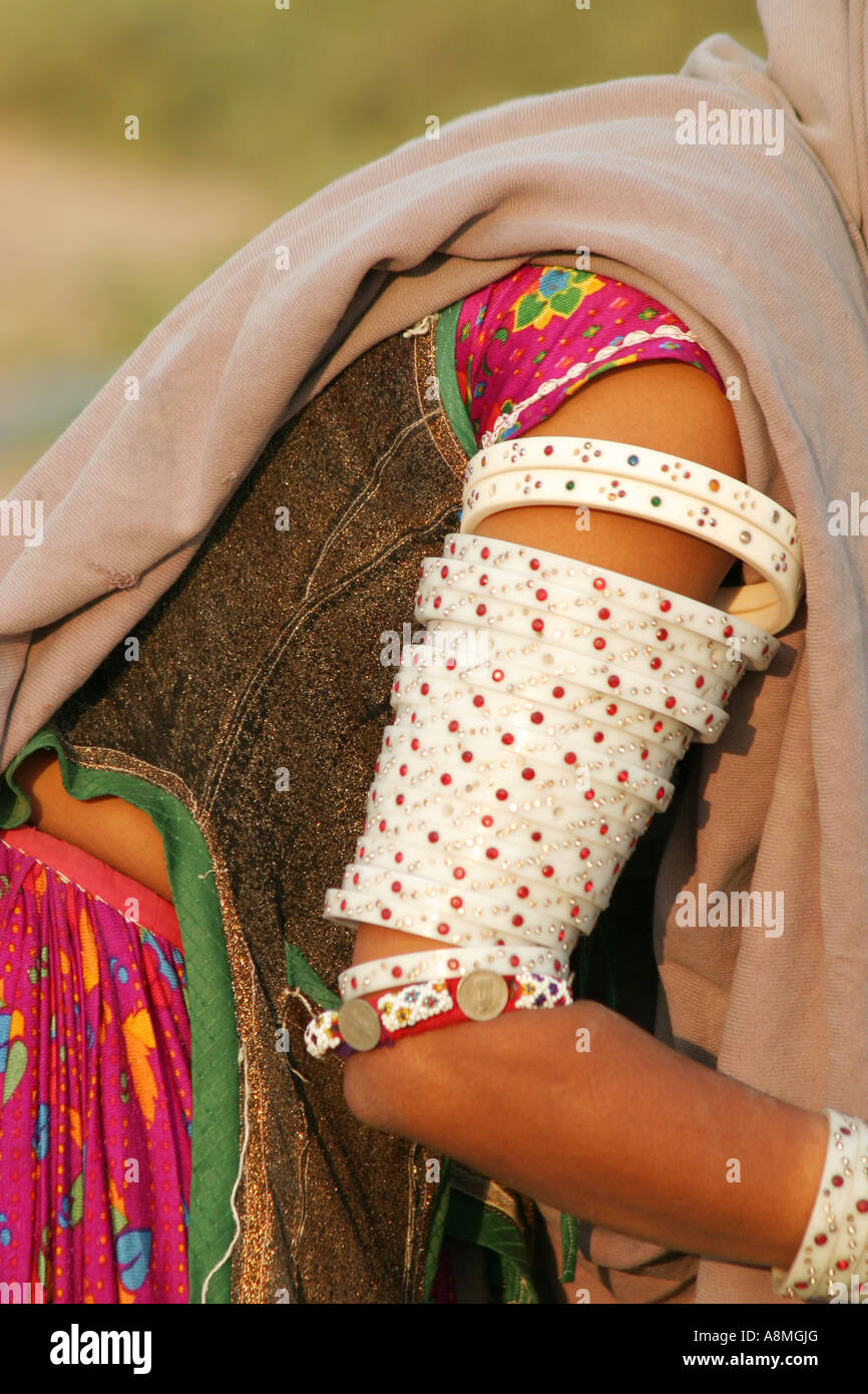 A Mir tribal womans arm covered with bracelets of plastic inlaid with coloured stones.Gujarat India Stock Photo