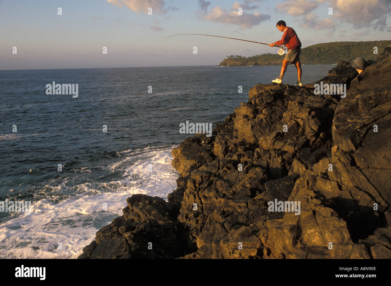 Australian fisherman Rock fishing at sunrise near Noosa Queensland Australia Stock Photo