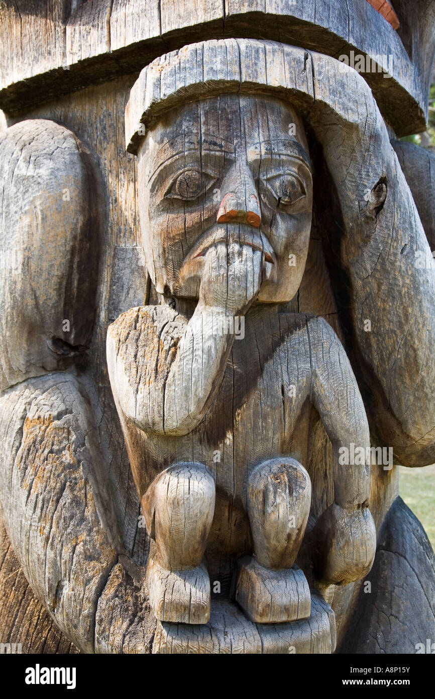 Small person with fingers in mouth carved in wood as part of totem pole Victoria Canada Stock Photo