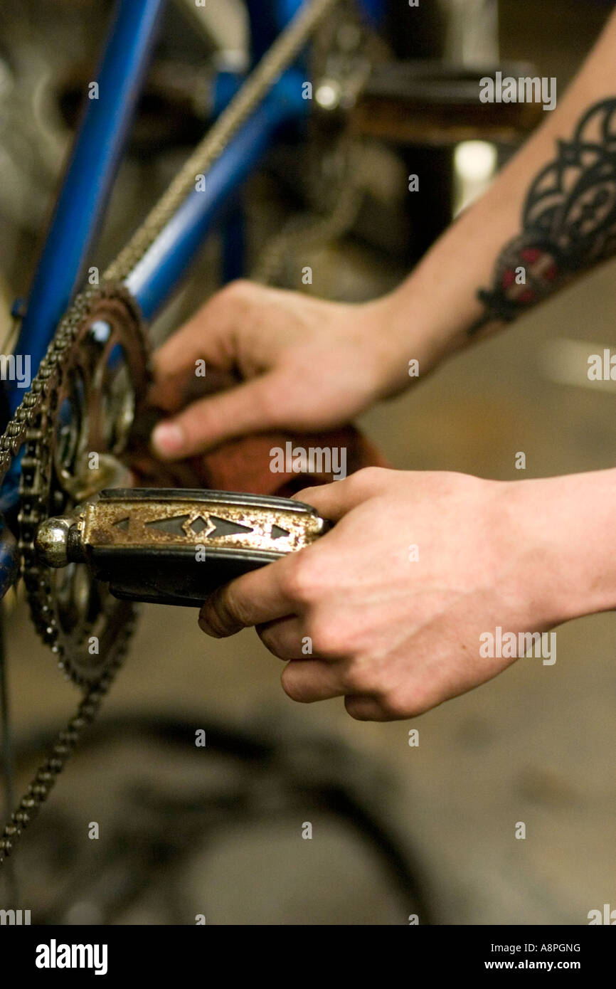 Worker Inspecting peddle and chain for a bicycle repair. Youth Express Bike Shop St Paul Minnesota USA Stock Photo Alamy