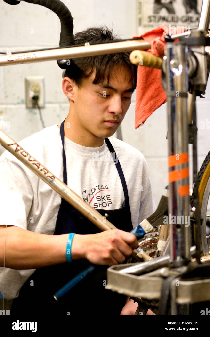 Asian American worker making a repair on a bicycle frame. Youth Express