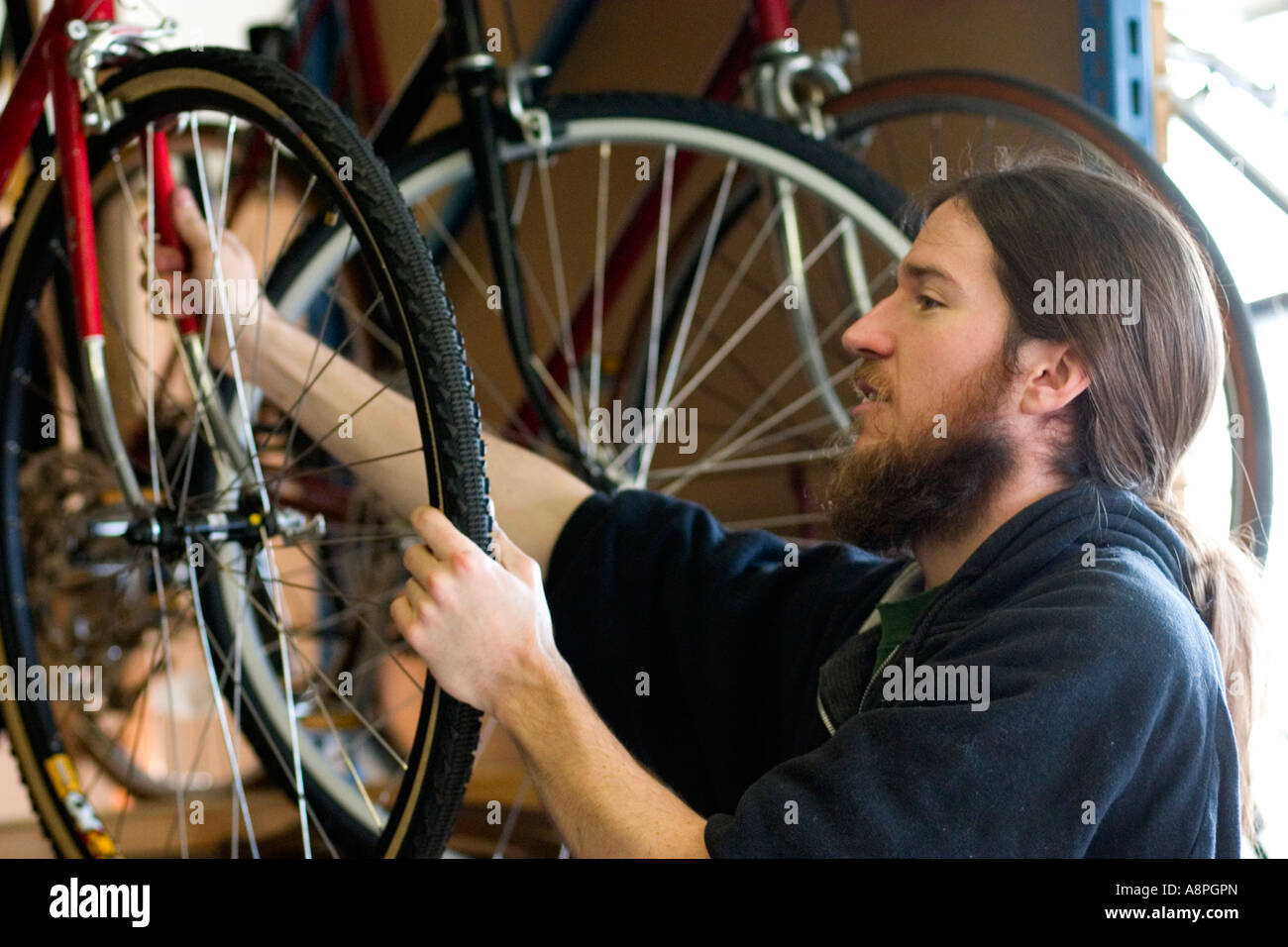 Worker inspecting bicycle wheel. Youth Express Bike Shop St Paul
