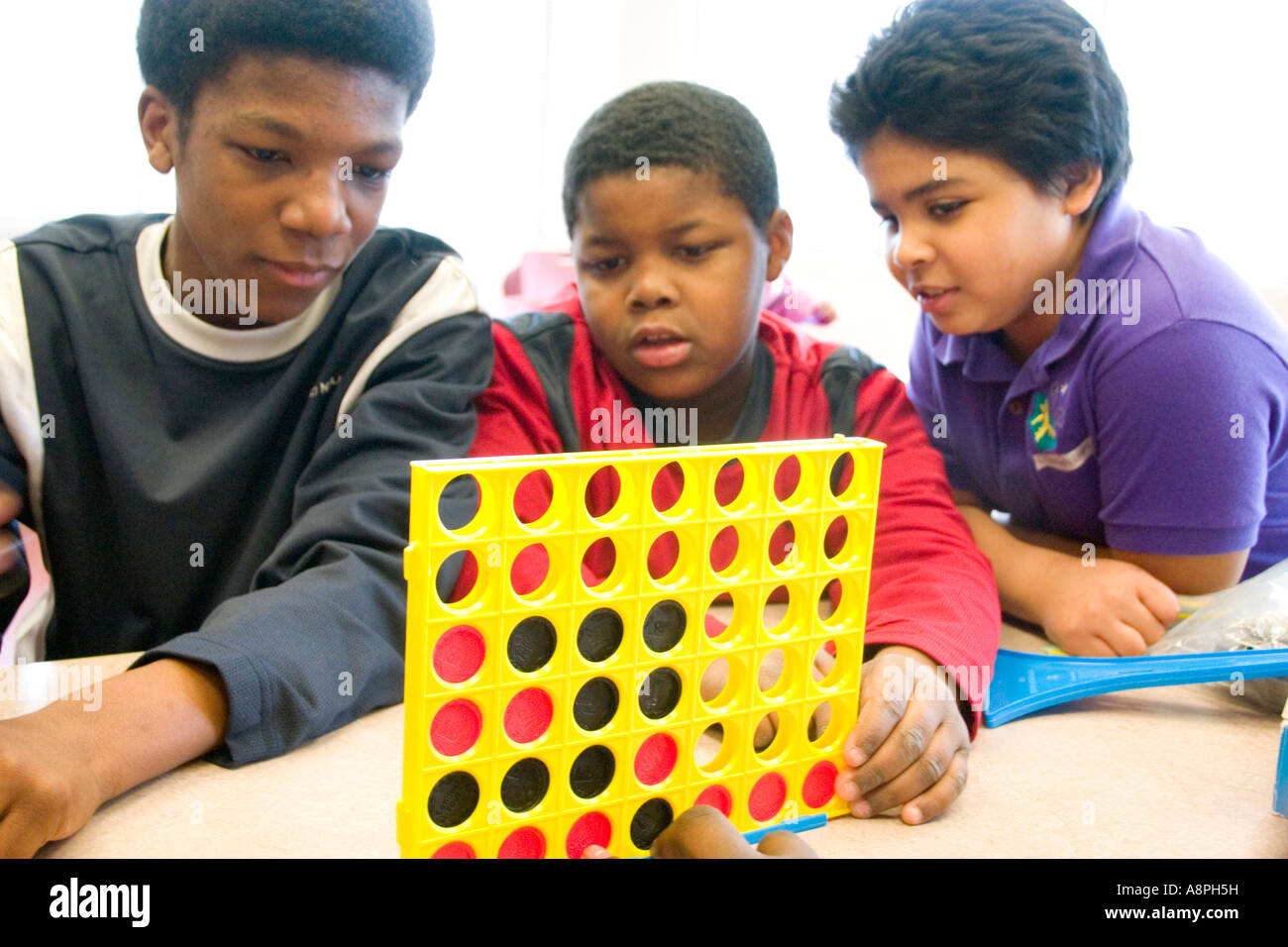 Boys playing Connect Four vertical checker game. After School Study