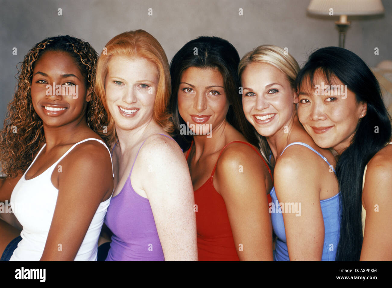 Colorful ethnic mixture of five female friends smiling Stock Photo