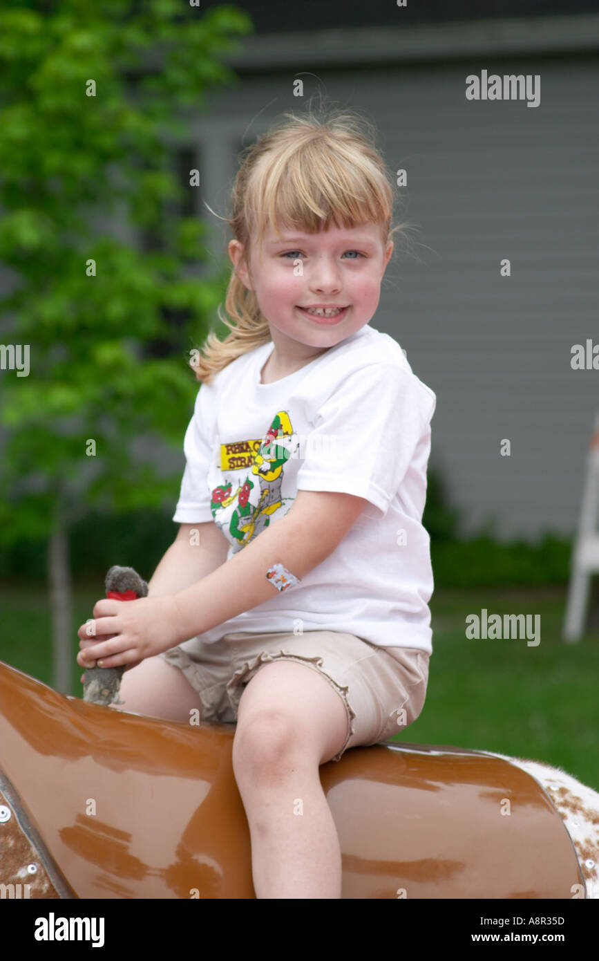 A little girl riding a mechanical bull at the East Tennessee Strawberry