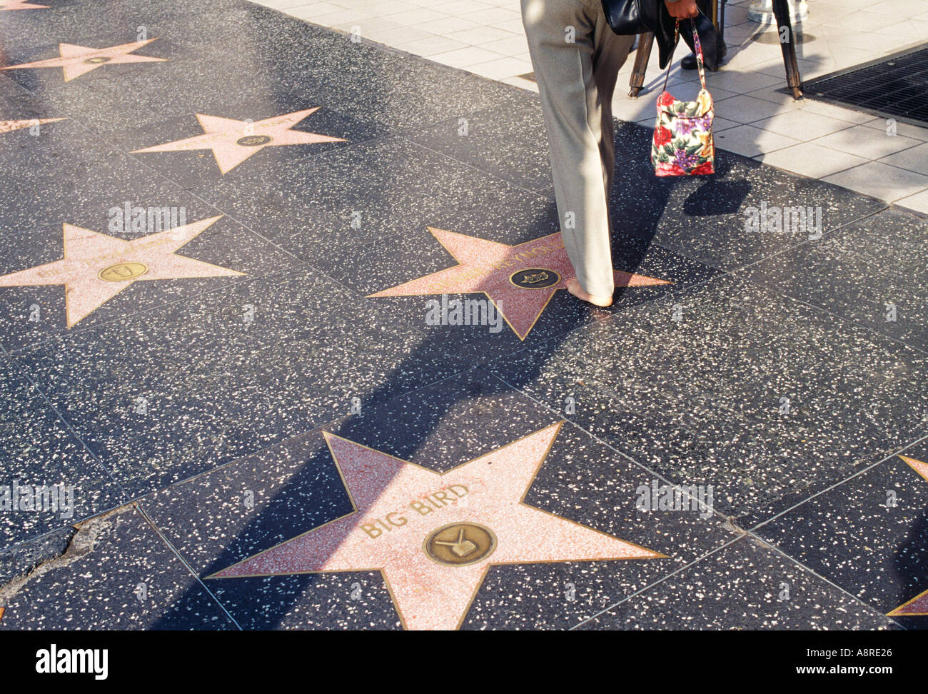 A woman walking on the Walk of Fame pavement in Hollywood Los Angeles ...