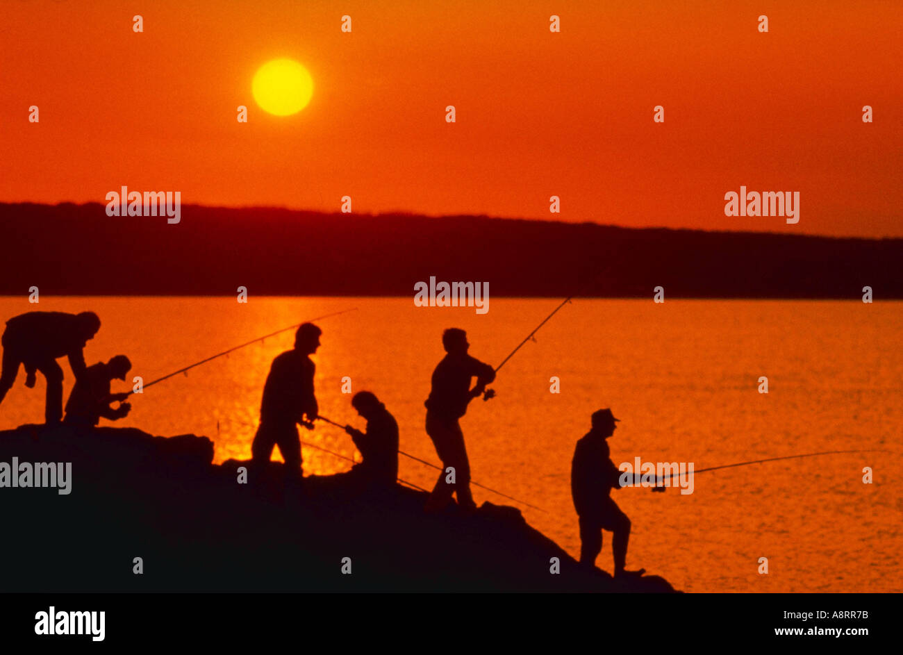 Silhouette of fishermen at sunset Stock Photo - Alamy