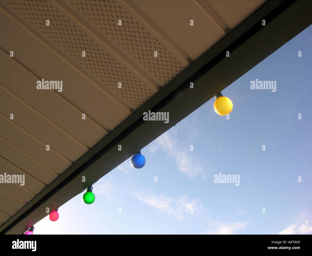Colored lights hanging from eaves of roof Stock Photo Alamy