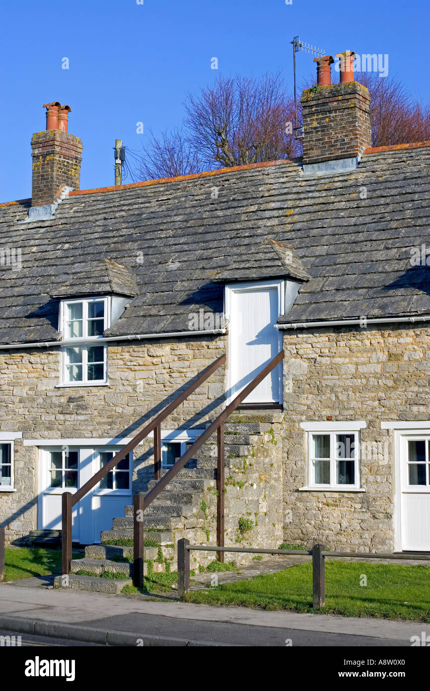 Traditional stone clad house with stone steps leading to the road on a ...