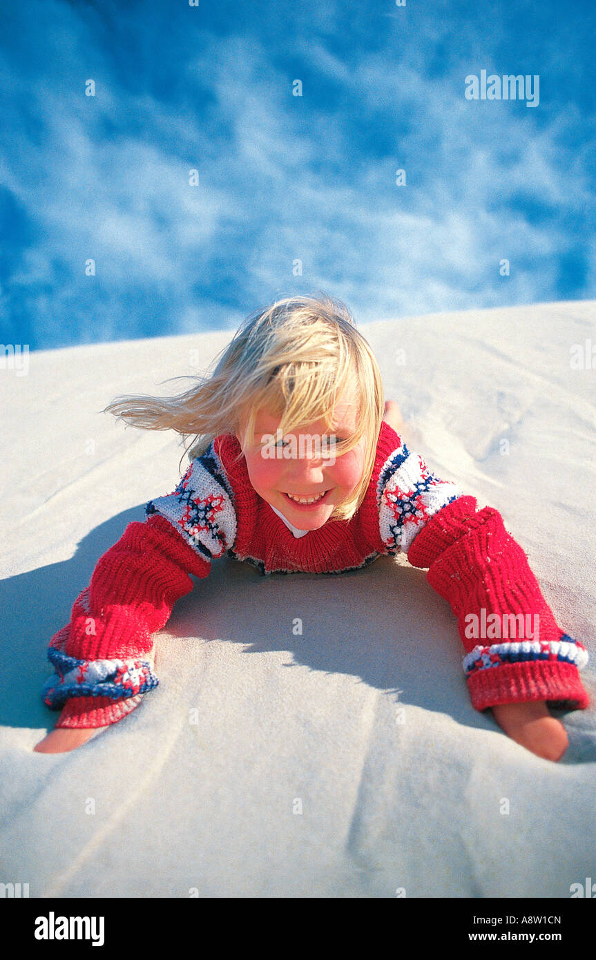 Children. Girl having fun sliding down sand dune at the beach Stock Photo Alamy
