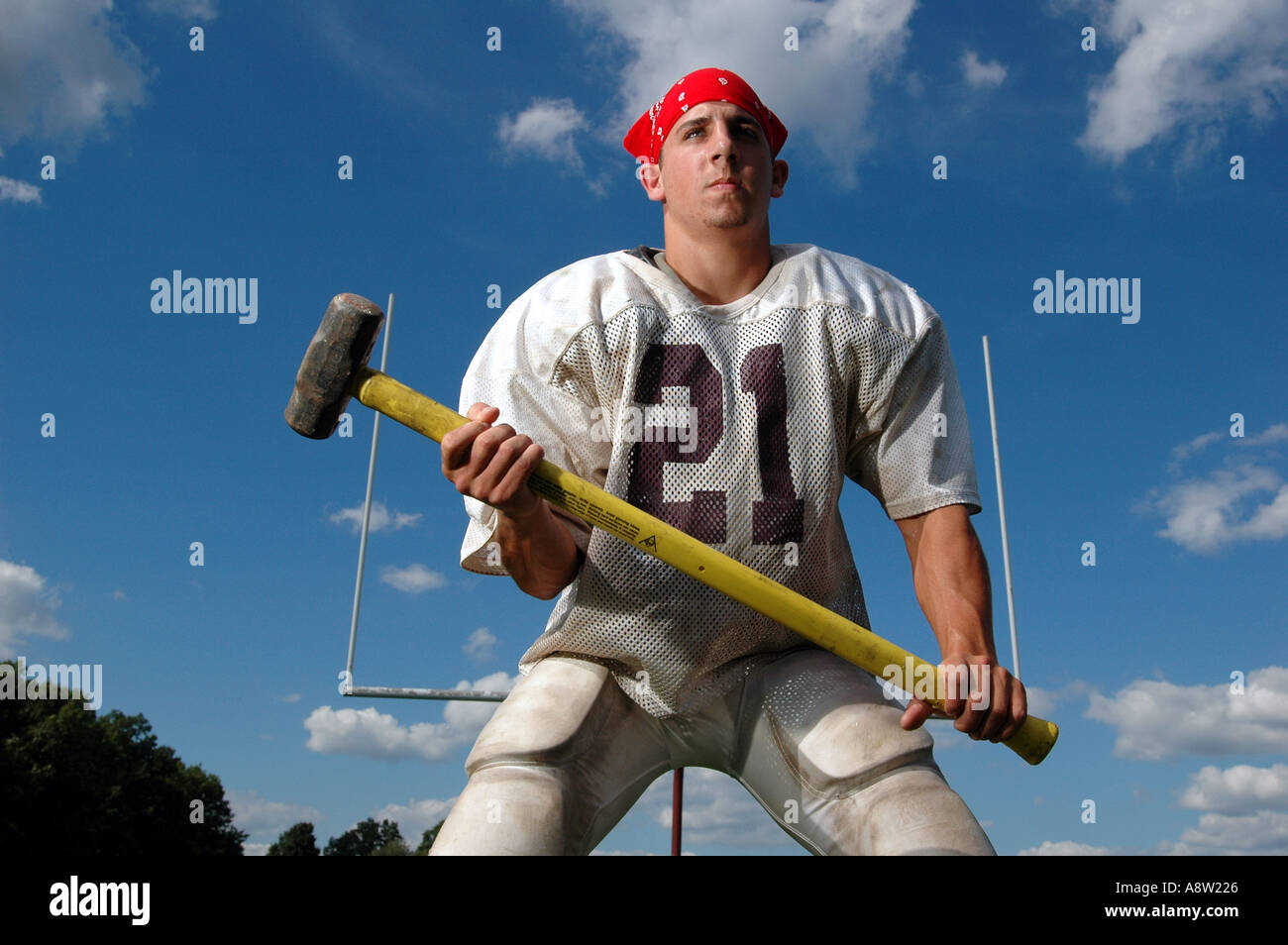 A tough football player holding a sledge hammer Stock Photo Alamy