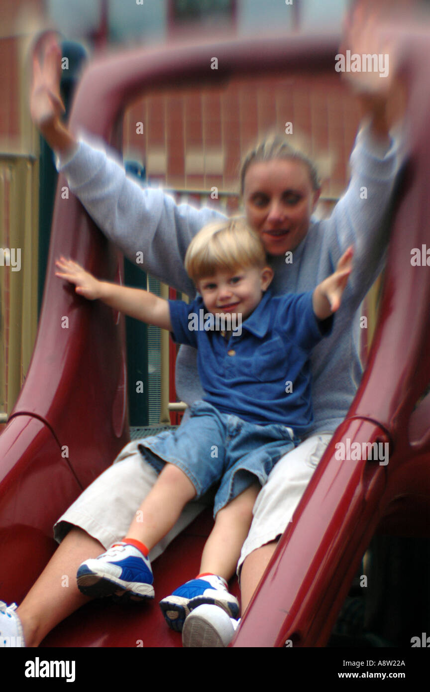 Mother and child playing on small slide Stock Photo