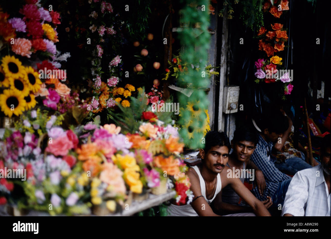 Indian men by flower stall in Delhi's Chandni Chowk market Stock Photo
