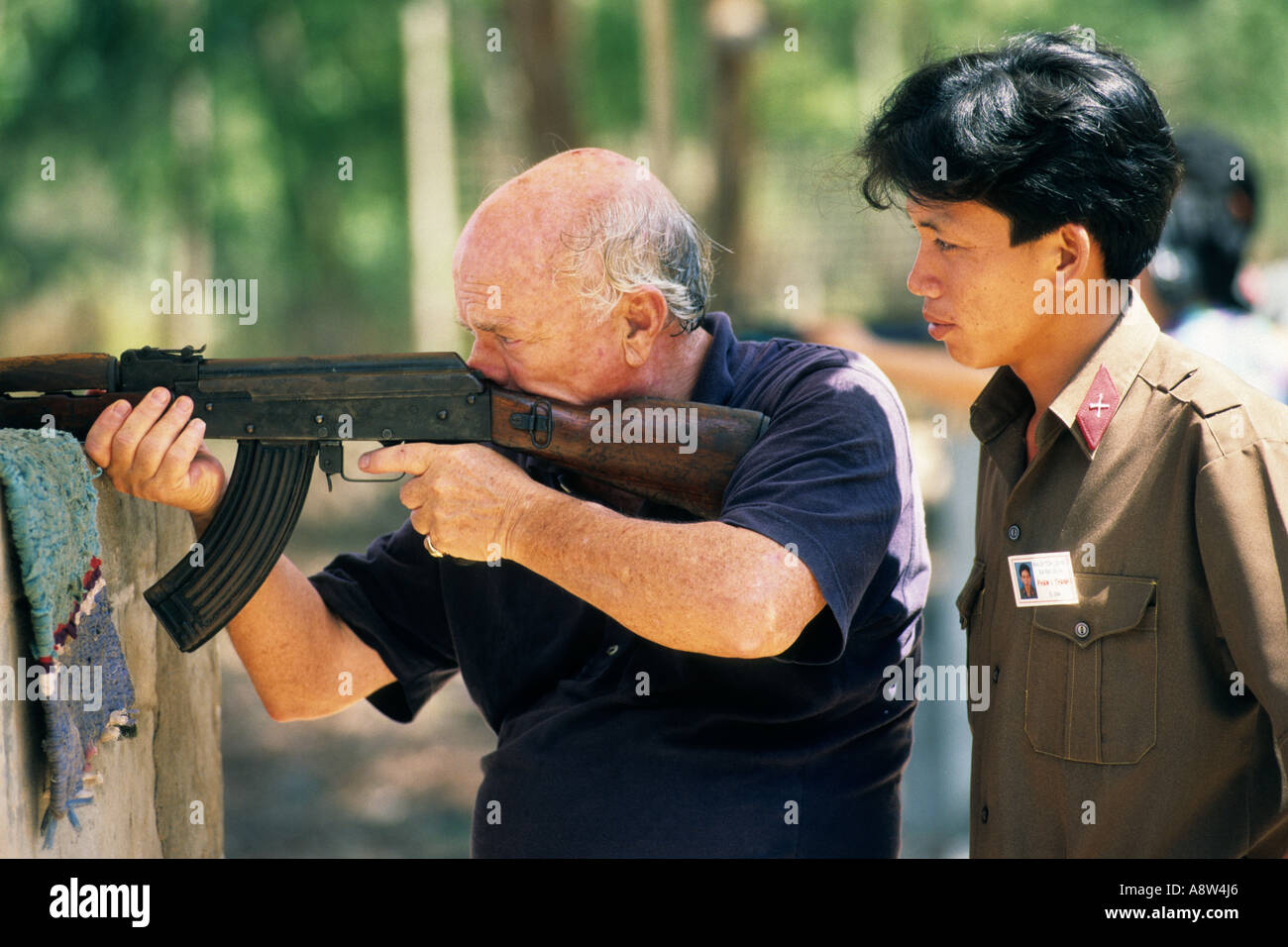 Asia, Vietnam, Cu Chi, Former Vietnam veteran during a shooting exercise on a shooting stand for tourist Stock Photo