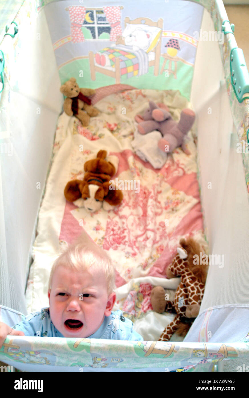 An eightmonth old baby boy crying in his cot Stock Photo Alamy