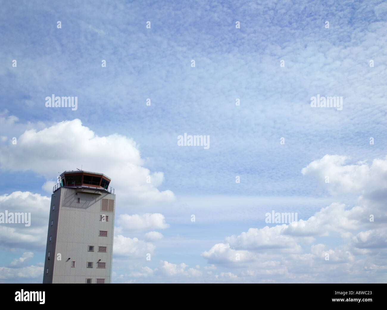 Airport control tower with blue sky and clouds in background Stock Photo