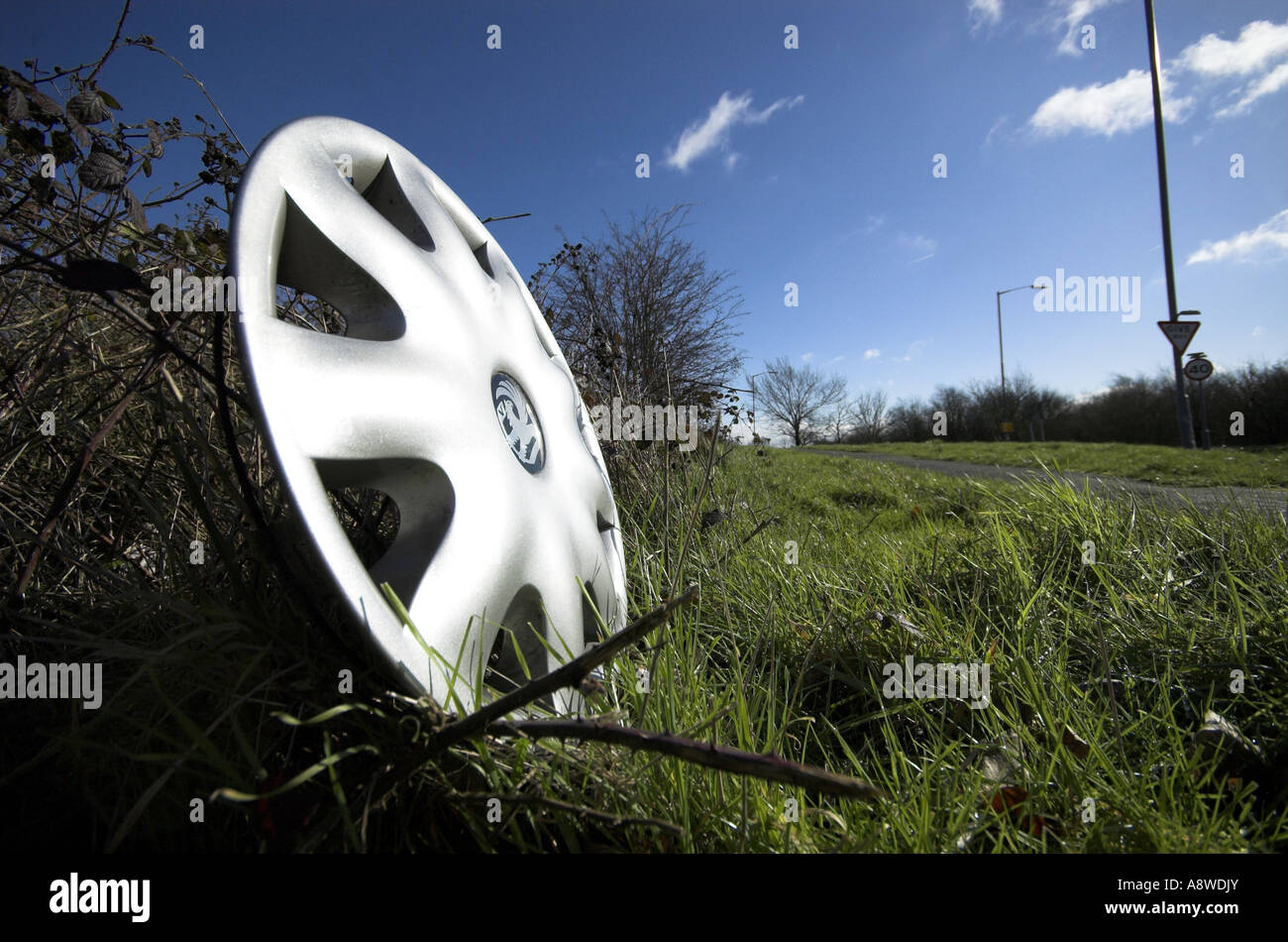 Silver car wheel hub cap on the side of the road close up Stock Photo
