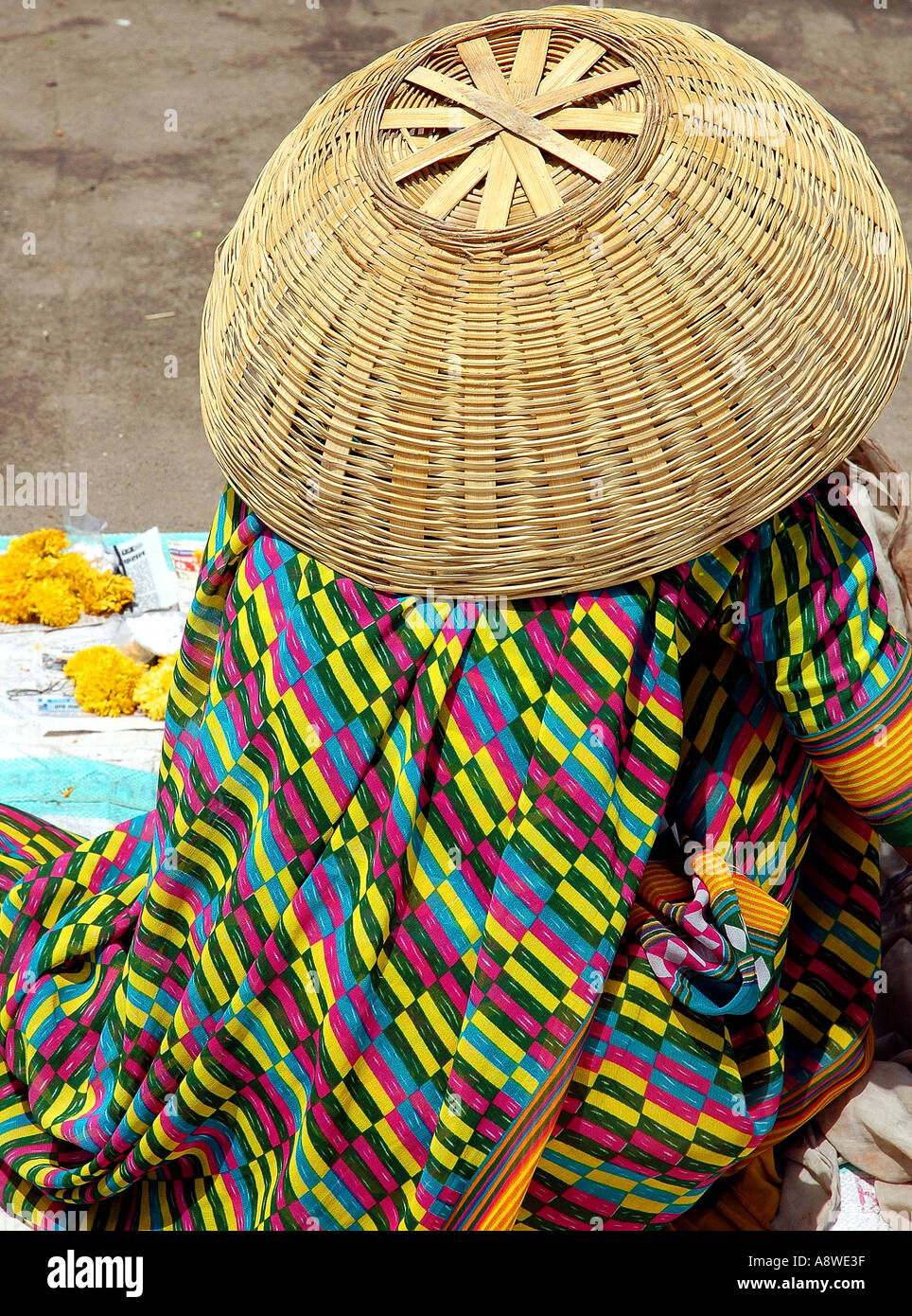 cane basket as hat by flower seller woman Ujjain India Stock Photo