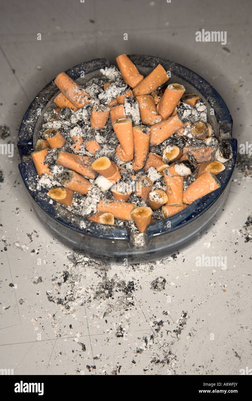 Ashtray spilling over with cigarette butts Stock Photo