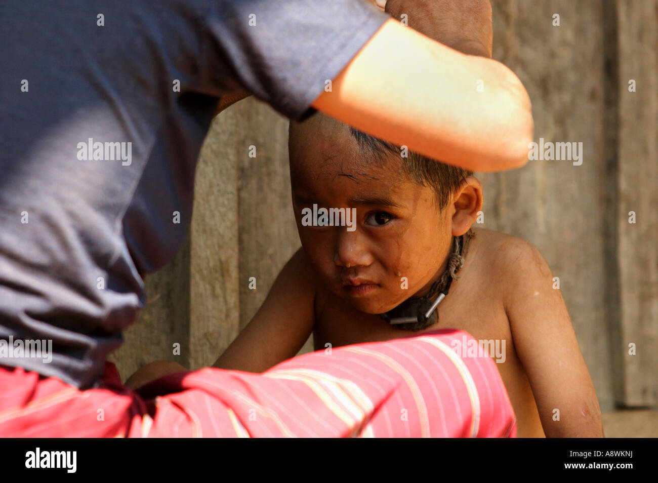 Asia, Myanmar, child having head shaved Stock Photo