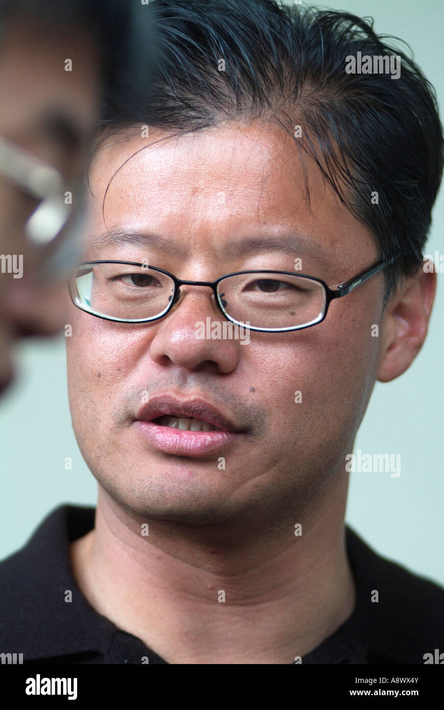 Jerry Yang Co-Founder and CEO of Yahoo Inc talks with a co worker in Silicon Valley CA Photo by Chuck Nacke Stock Photo