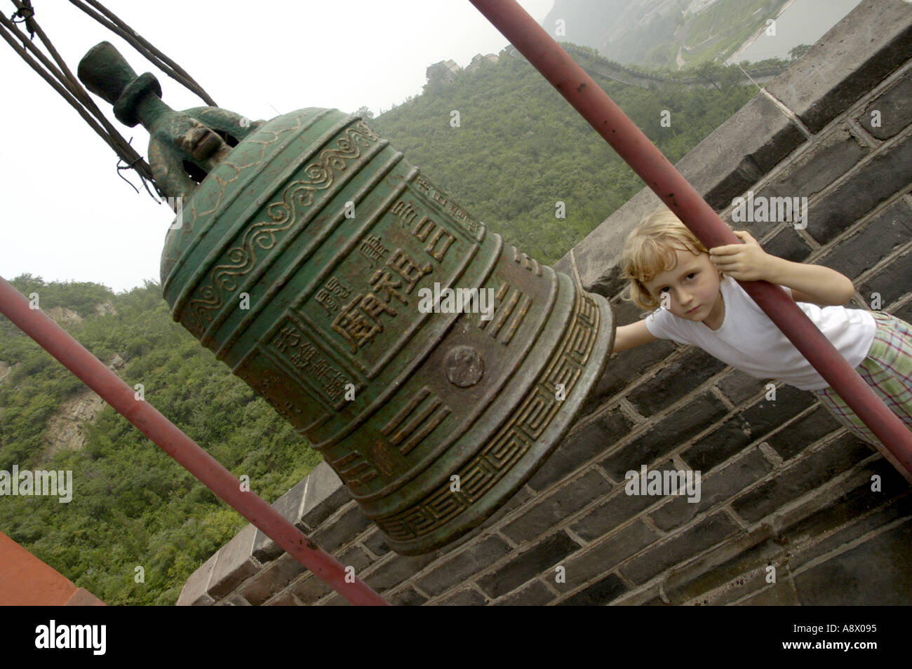 China Beijing Blond Little Girl Playing With A Big Bronze Bell On The Great Wall At Juyongguan Gate Near Badaling Stock Photo