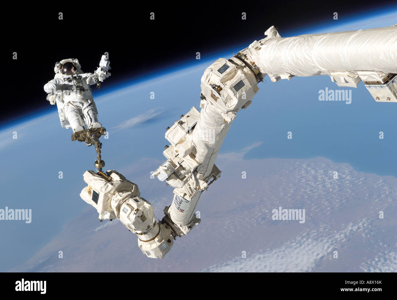 Astronaut Stephen K Robinson anchored to a foot restraint on the International Space Stations Canadarm2 Stock Photo