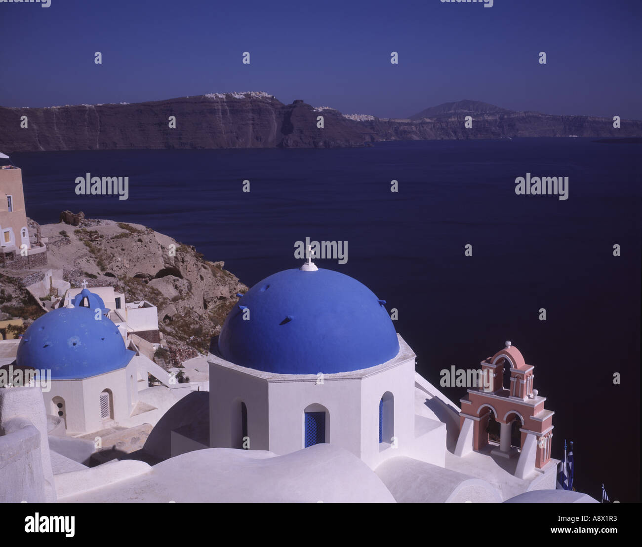 Greek Orthodox church with blue domes on crater rim at town Oia volcanic island Santorini Aegean sea Mediterranean sea Greece Stock Photo