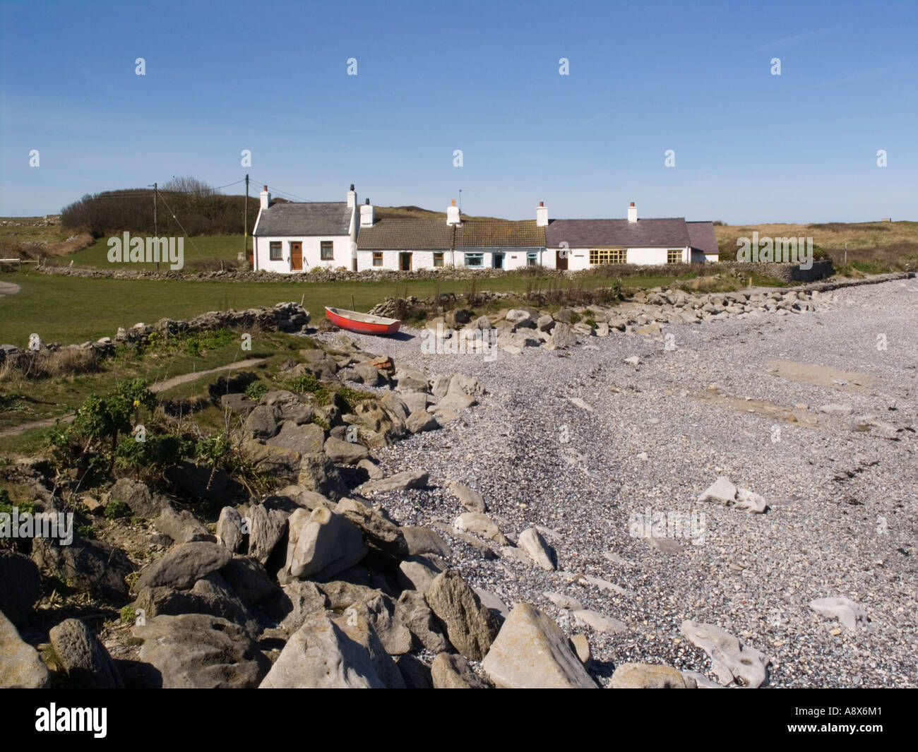 Shingle Beach With Row Of White Cottages Beside Anglesey Coastal