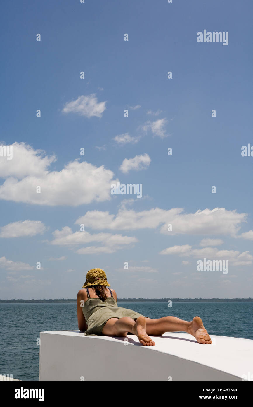 Woman lying on white platform by the sea Stock Photo