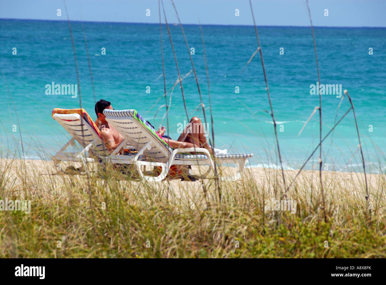 Partial view of a man and woman relaxing on a beach Stock Photo