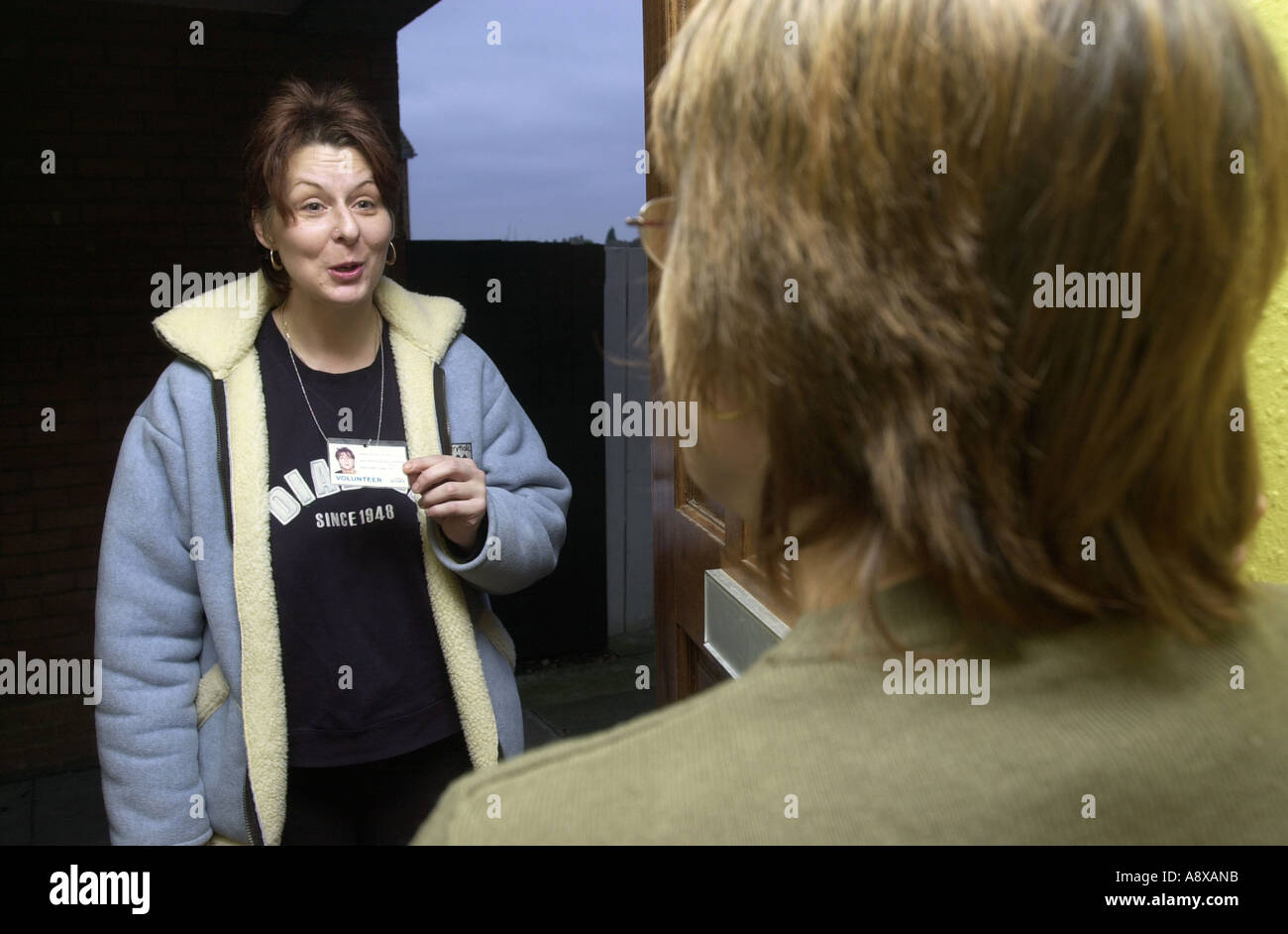 Woman worker shows her ID on the doorstep UK Stock Photo