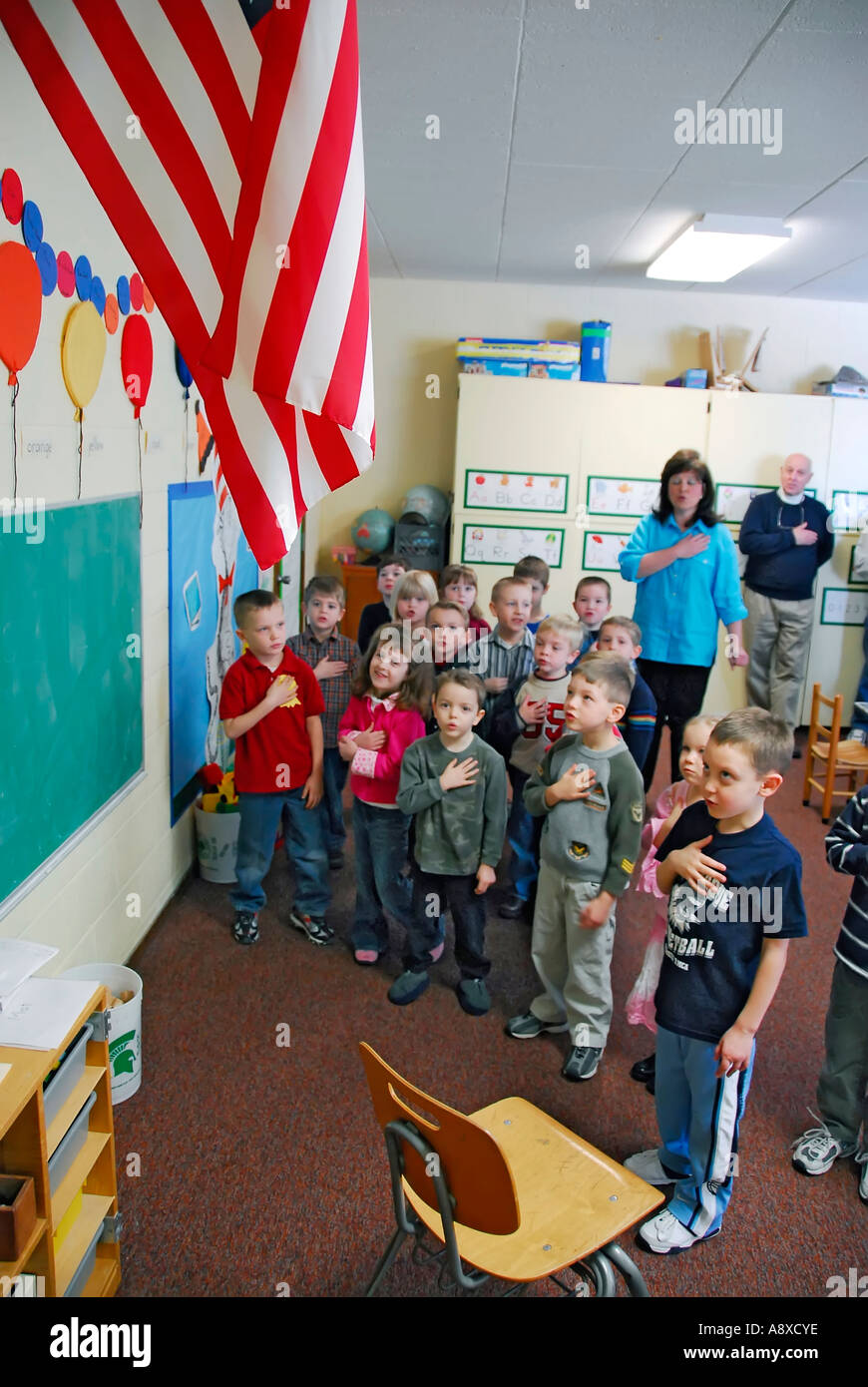 Children say pledge of allegiance to the American flag in pre nursery school Stock Photo