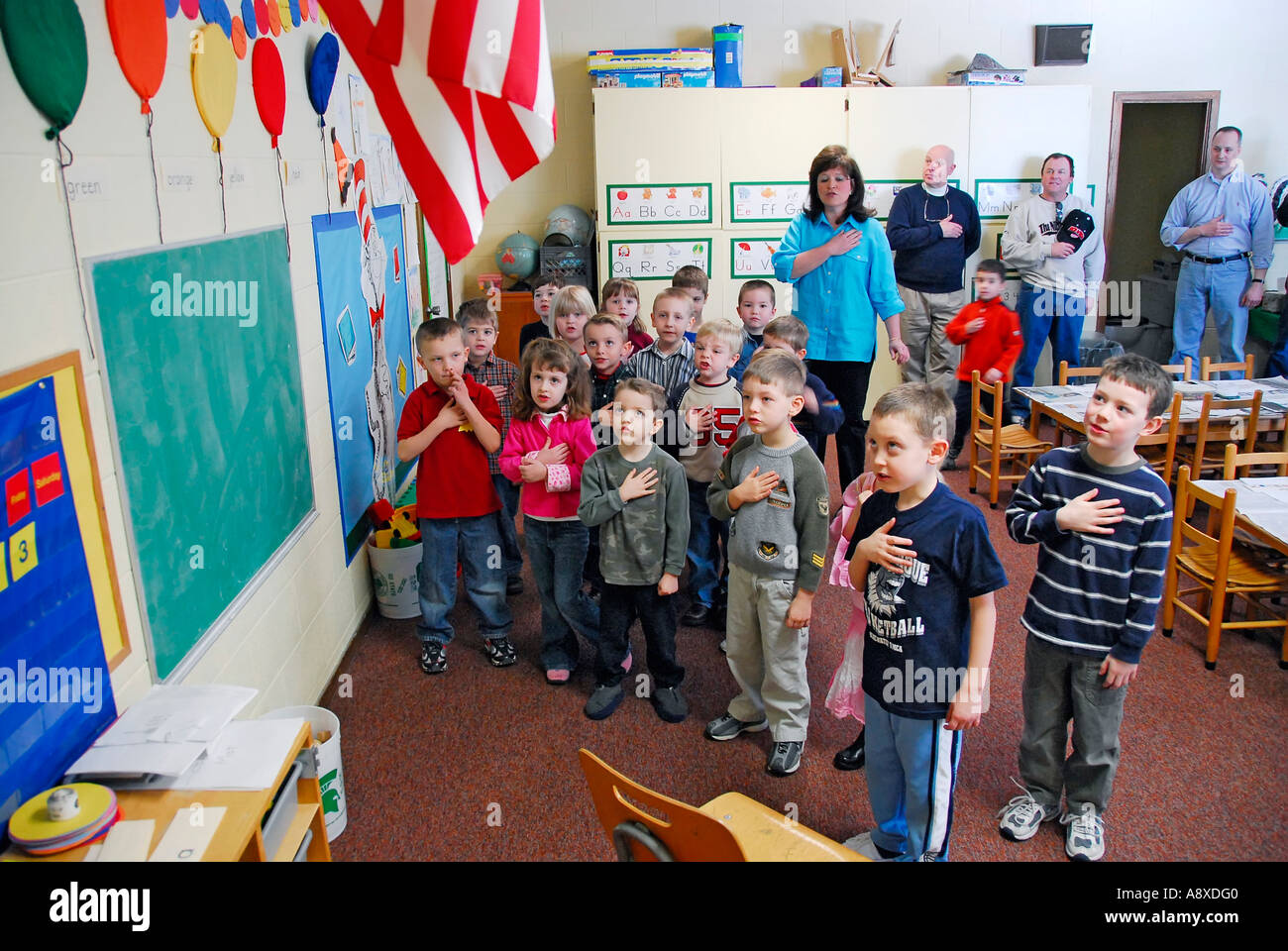 Children say pledge of allegiance to the American flag in pre nursery school Stock Photo