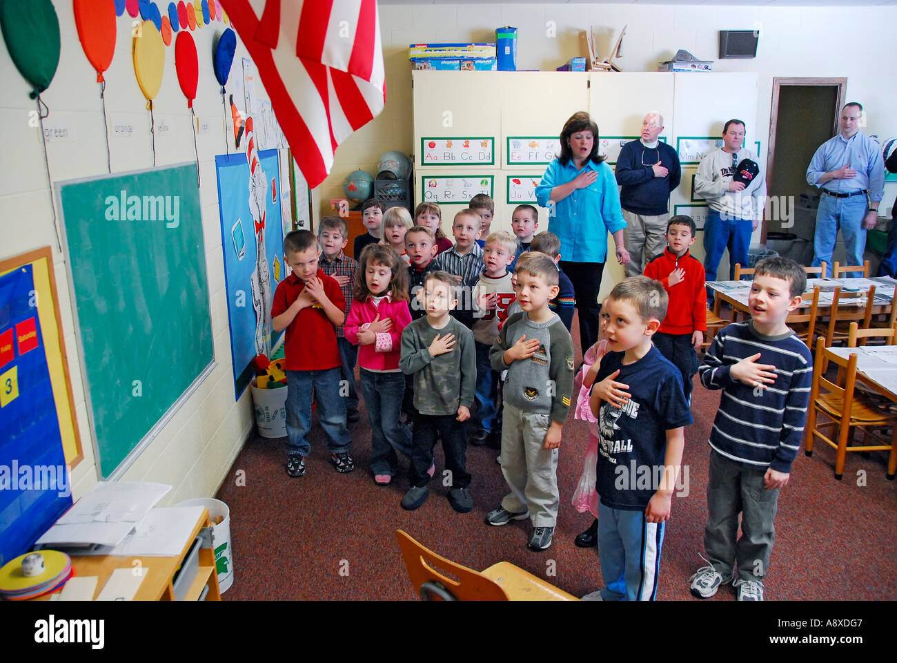 Children say pledge of allegiance to the American flag in nursery school Stock Photo