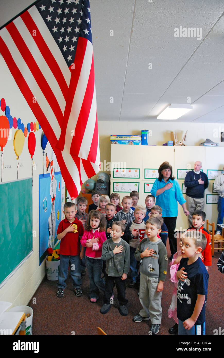 Children say pledge of allegiance to the American flag in pre nursery school Stock Photo