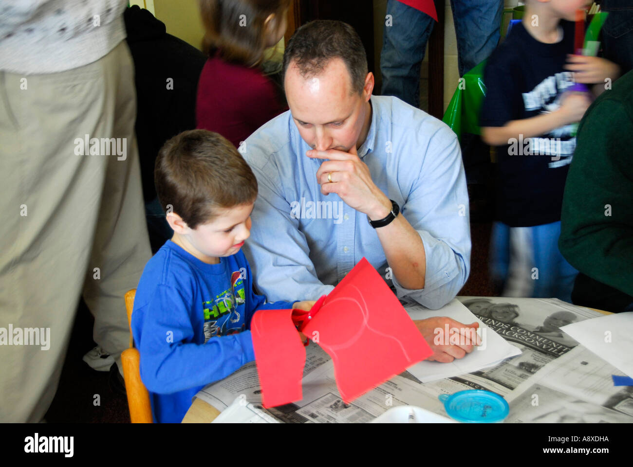 Father attends special educational progress report day with son daughter attending nursery pre school Stock Photo